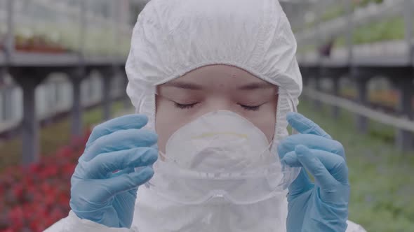 Close-up Face of Female Biologist or Scientist Putting on Protective Eyeglasses. Portrait of Young