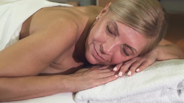 Relaxed Woman Lies on a Massage Table