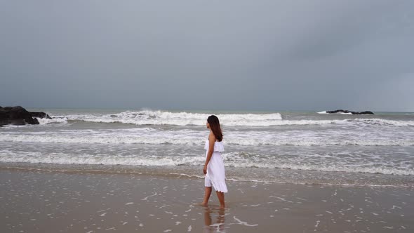 Young woman feeling lonely and sad looking at the sea on a gloomy day