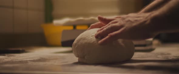 Chef checking the shape of the traditional pizza dough. Close up, slow motion