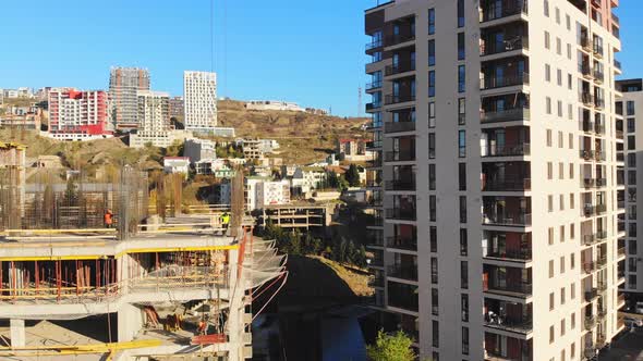 Workers On Construction Site In Sunny Day