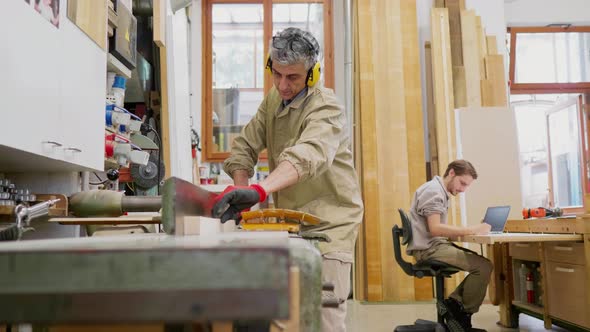 Carpenter with ear protections working on sanding machine