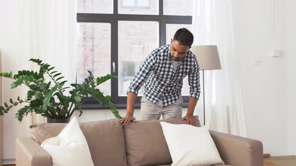 Indian Man Arranging Sofa Cushions at Home 44