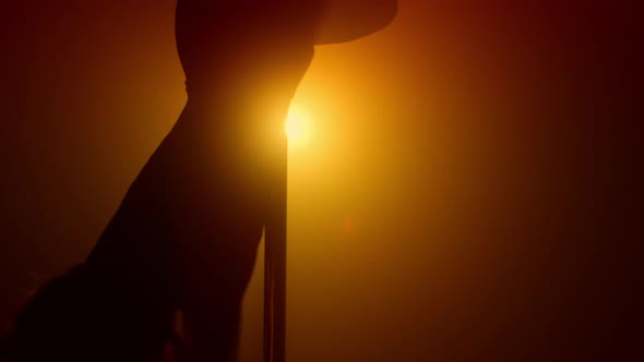 Silhouette Woman Performing Poledance in Spotlight