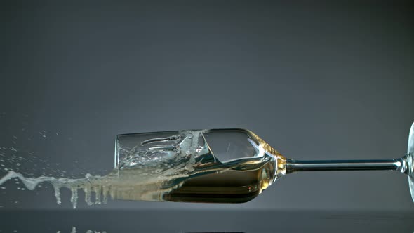 Falling Glass with Champagne on Grey Background at 1000 Fps