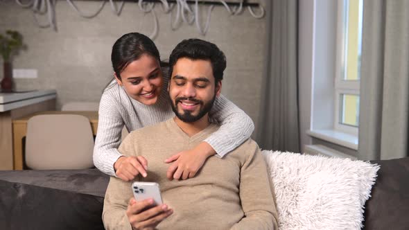 Cheerful Couple Spends Time with Smartphone at Home