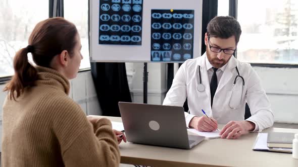 Attentive Smart Caucasian Male Doctor of General Medicine Consults a Female Patient in a Medical