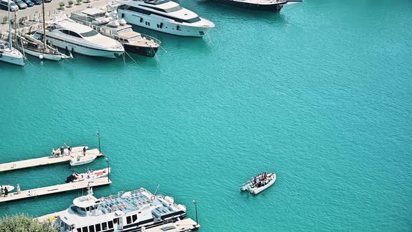 View of the sea port in Nice, France. Moored yachts, moving boat with people, blue water of the Medi