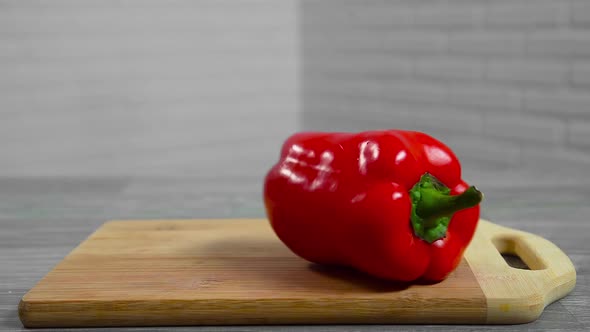 Bell pepper falls on a bamboo cutting board