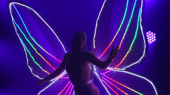 Actress As a Butterfly with Flashing Glowing Wings. Woman Singing and Dancing in the Studio with