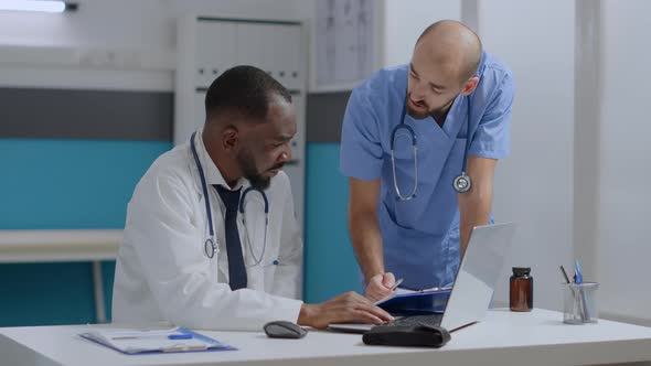 Multiethnic Team Discussing Healthcare Treatment Analyzing Sickness Expertise Documents