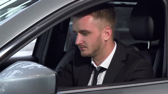 Young Businessman Looking To the Camera Confidently, Sitting in a New Car