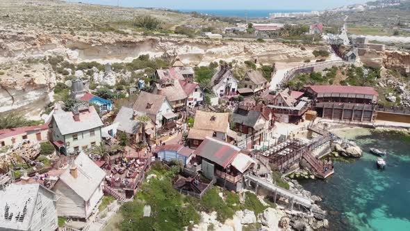 Low level orbit aerial shot of Mediterranean Anchor Bay overlooking Popeye Village, Maltac