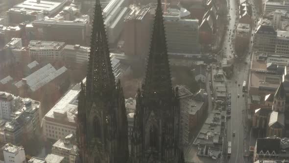 AERIAL: Close Up Circling Around Cologne Cathedral in Beautiful Hazy Sunlight with Rain 
