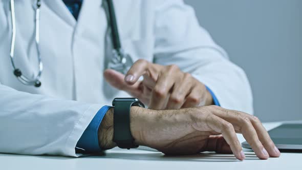 Close Up Shot of the Doctors Hand Who Uses a Smart Watch to Check the Pressure