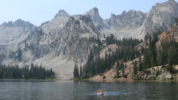 Man swims in Alice Lake - Sawtooth Mountains, Idaho - Summer