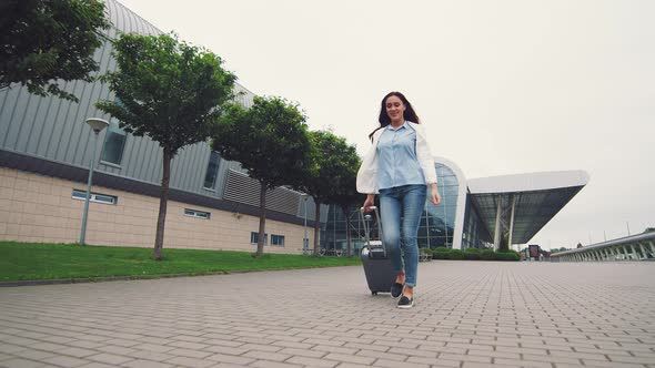 Woman Walking with Luggage. Arrival or Departure To a New Country. A Businesswoman Walks Down the