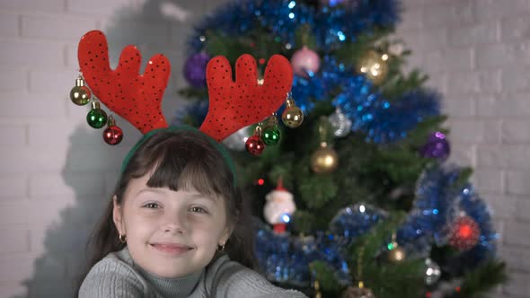 Smiling child with Christmas deer antlers