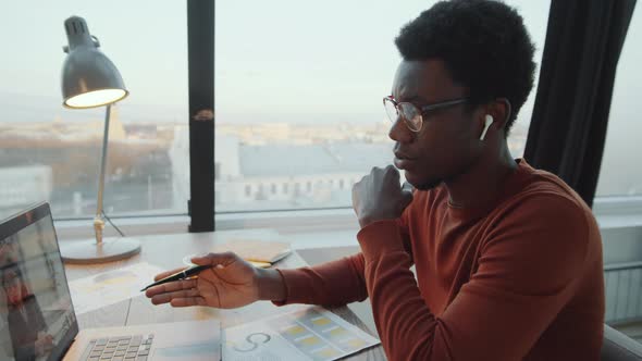 Black Businessman Speaking with Colleague on Video Call on Laptop