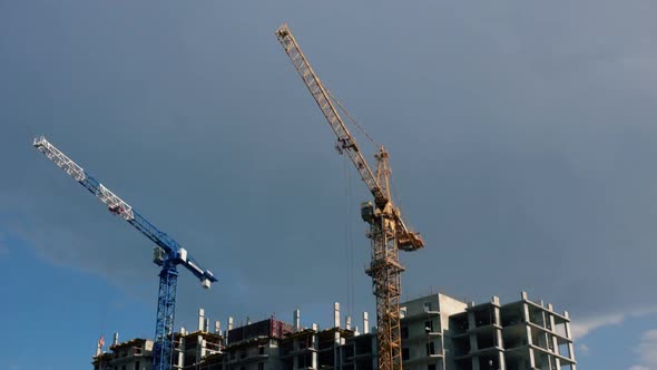 Construction site with cranes against a cloudy sky. TimeLaps. Construstion Concept