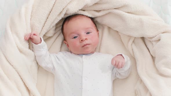 Top View of Adorable 1 Months Old Baby Boy Lying on Soft Blanket and Looking in Camera