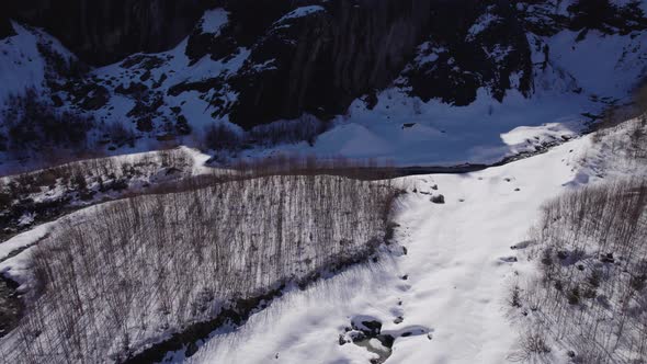 aerial footage of glacial landscape in Swiss Alps, flying backwards