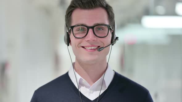 Young Businessman with Headset Smiling at the Camera