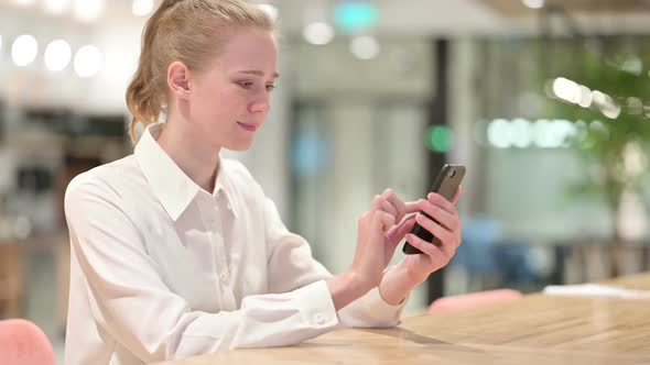 Serious Young Businesswoman Using Smartphone