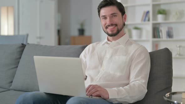 Attractive Man with Laptop Smiling at the Camera