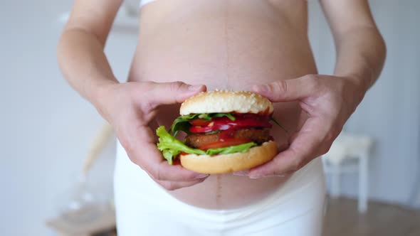 Pregnant Woman Holding Vegan Burger In Hands. Healthy Alternative To Junk Food