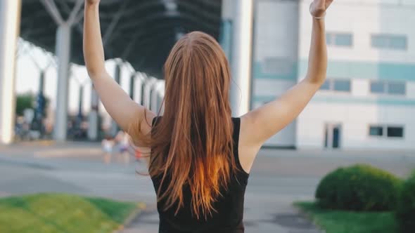 Beautiful Redhaired Woman with Long Hair on Street at Sunset