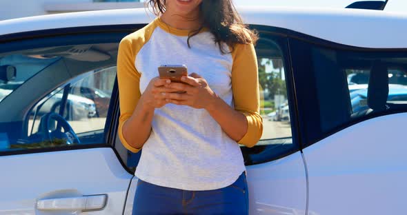 Woman using mobile phone near her car 4k