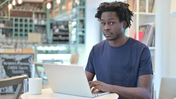 Thumbs Up By African Man with Laptop in Cafe