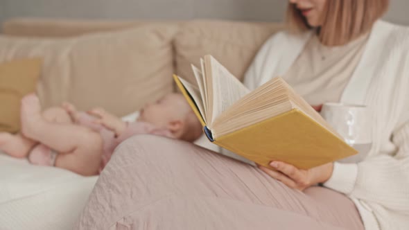 Babysitter Reading and Watching Infant