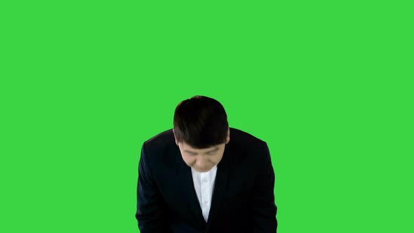Asian Man in Office Suit Making a Bow on a Green Screen Chroma Key
