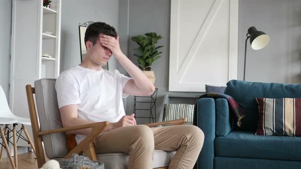 Man Sitting on Couch with Headache, Pain and Problems