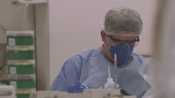 Male scientist working and experimenting with COVID-19 test samples in a medical lab. Medium shot.