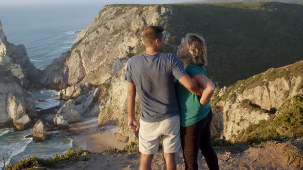 Married Couple of Tourists Standing at Cliff