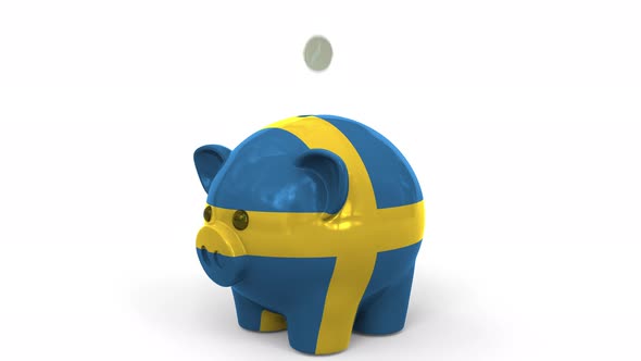 Coins Fall Into Piggy Bank Painted with Flag of Sweden alt