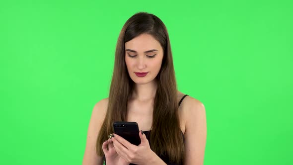 Young Woman Texting on Her Phone and Shocked. Green Screen