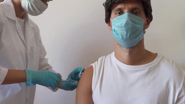 Portrait of Health Worker in Surgical Mask Making Coronavirus Vaccine Injection at Clinic