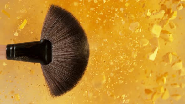 Super Slow Motion Shot of Makeup Brush and Golden Powder Explosion at 1000 Fps