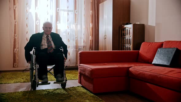 Elderly Grandfather - Happy Grandfather Is Riding His Wheelchair Around the Room