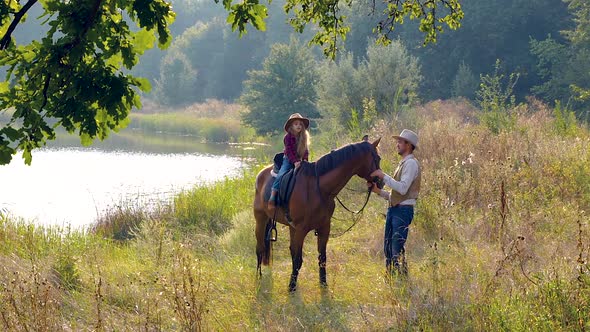 Cowboy and His Daughter on Horseback