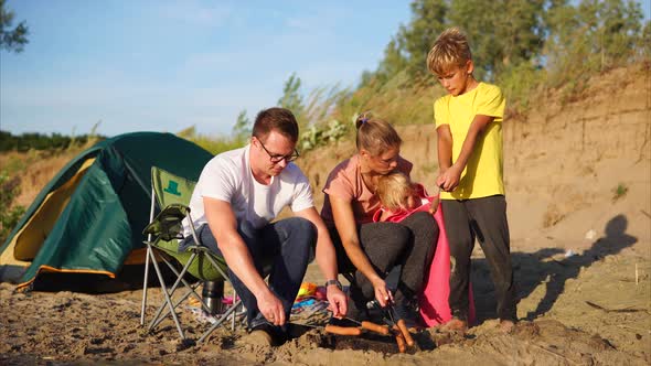 Family in Camp is Going to Eat Roasted Sausages