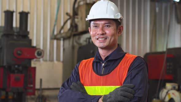 Asian male engineer foreman in arms crossed with vision standing at the factory