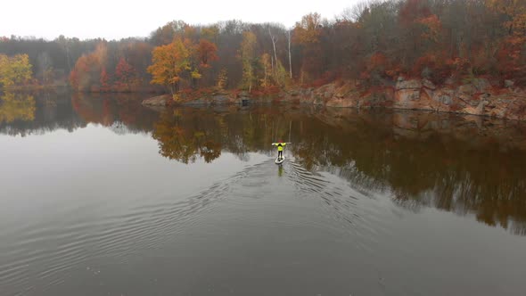 Drone Shot of Man and Woman on Sup Paddle Boards at Wide River on Golden Autumn Forest Background