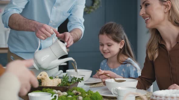 Father pouring tea during easter dinner. Shot with RED helium camera in 8K.