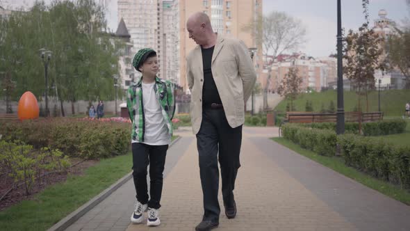 Portrait Grandfather and Grandson Walking To Camera in the Park