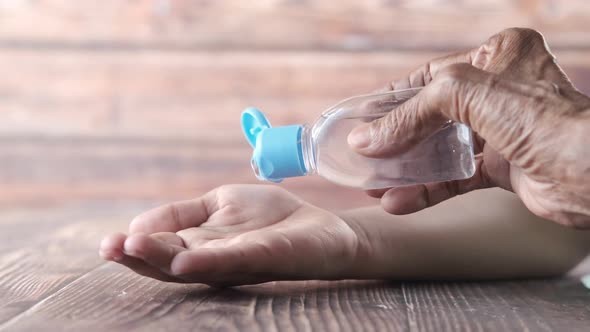 Senior Women Putting Hand Sanitizer on a Child Hand